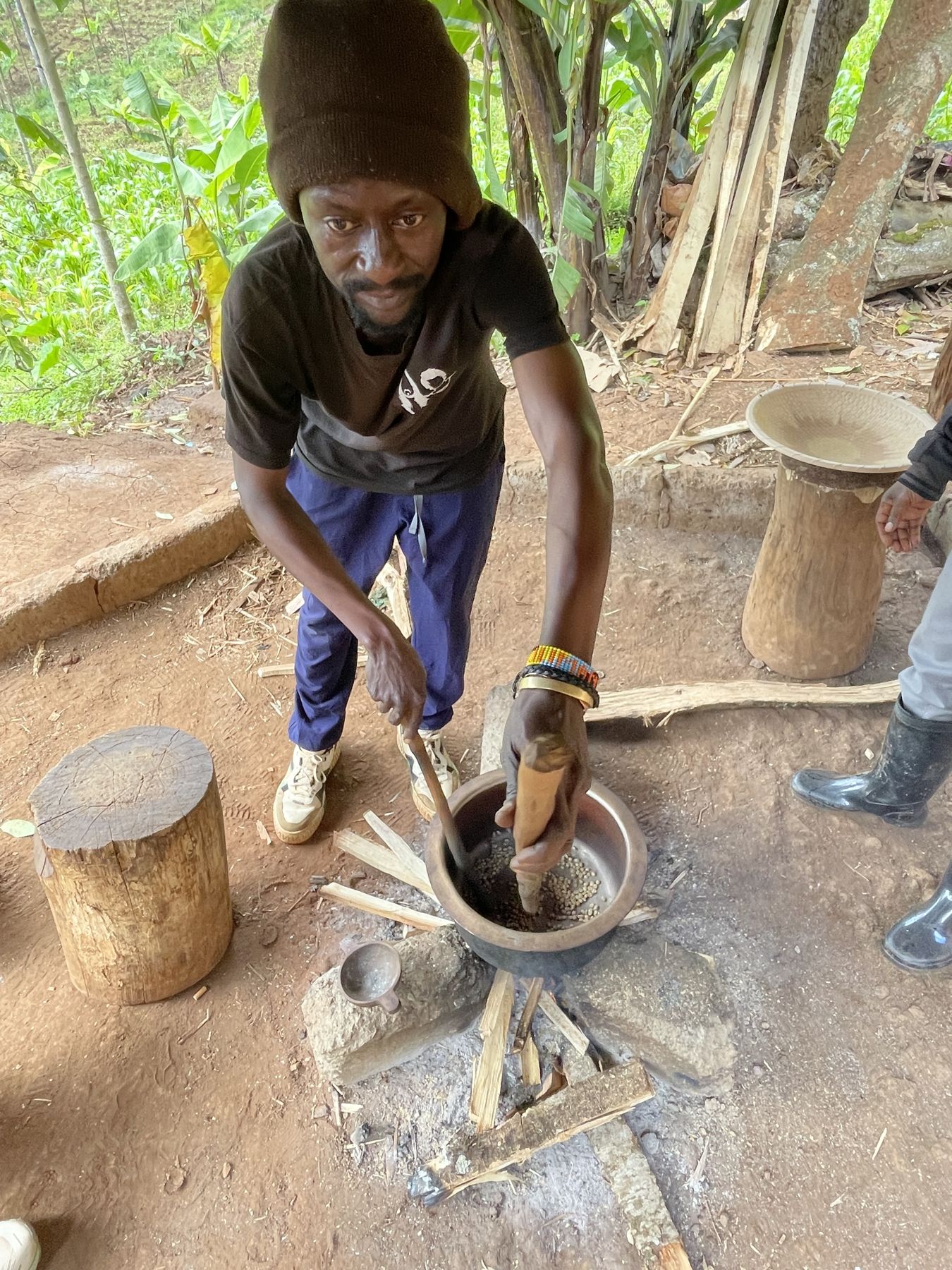 Coffee beans stirred in a pot over an open fire